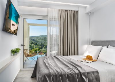 Minimal suite sleeping area with natural light and modern furnishings, Myzith Luxury Suites, Keri, Zakynthos, Greece.