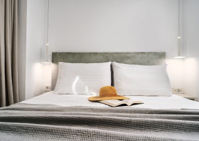 Minimal suite sleeping area with natural light and modern furnishings, Myzith Luxury Suites, Keri, Zakynthos, Greece.